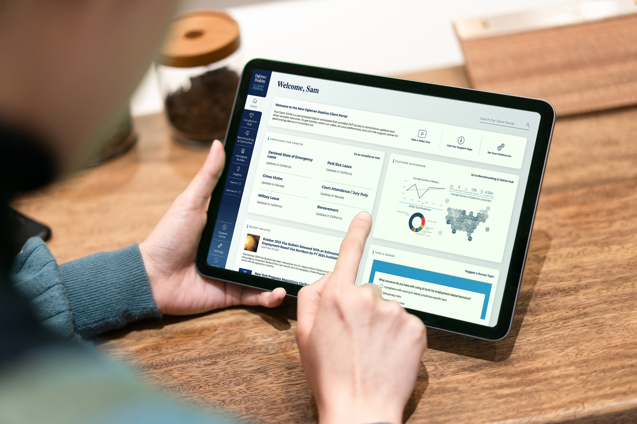 High angle of a person looking at analytics in the Client Portal on a tablet above a wood desk