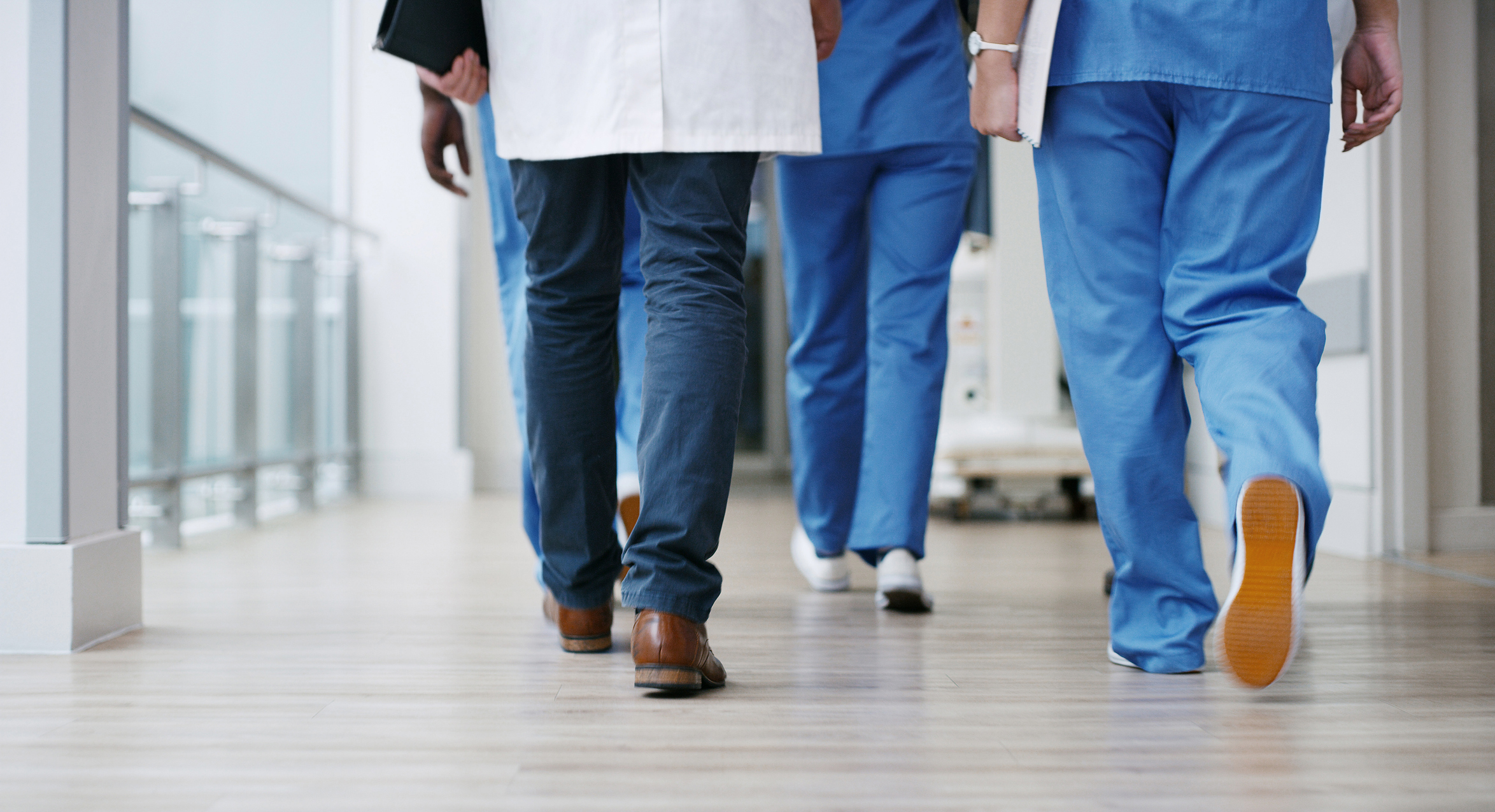 Closeup shot of a group of unrecognisable doctors walking in a hospital