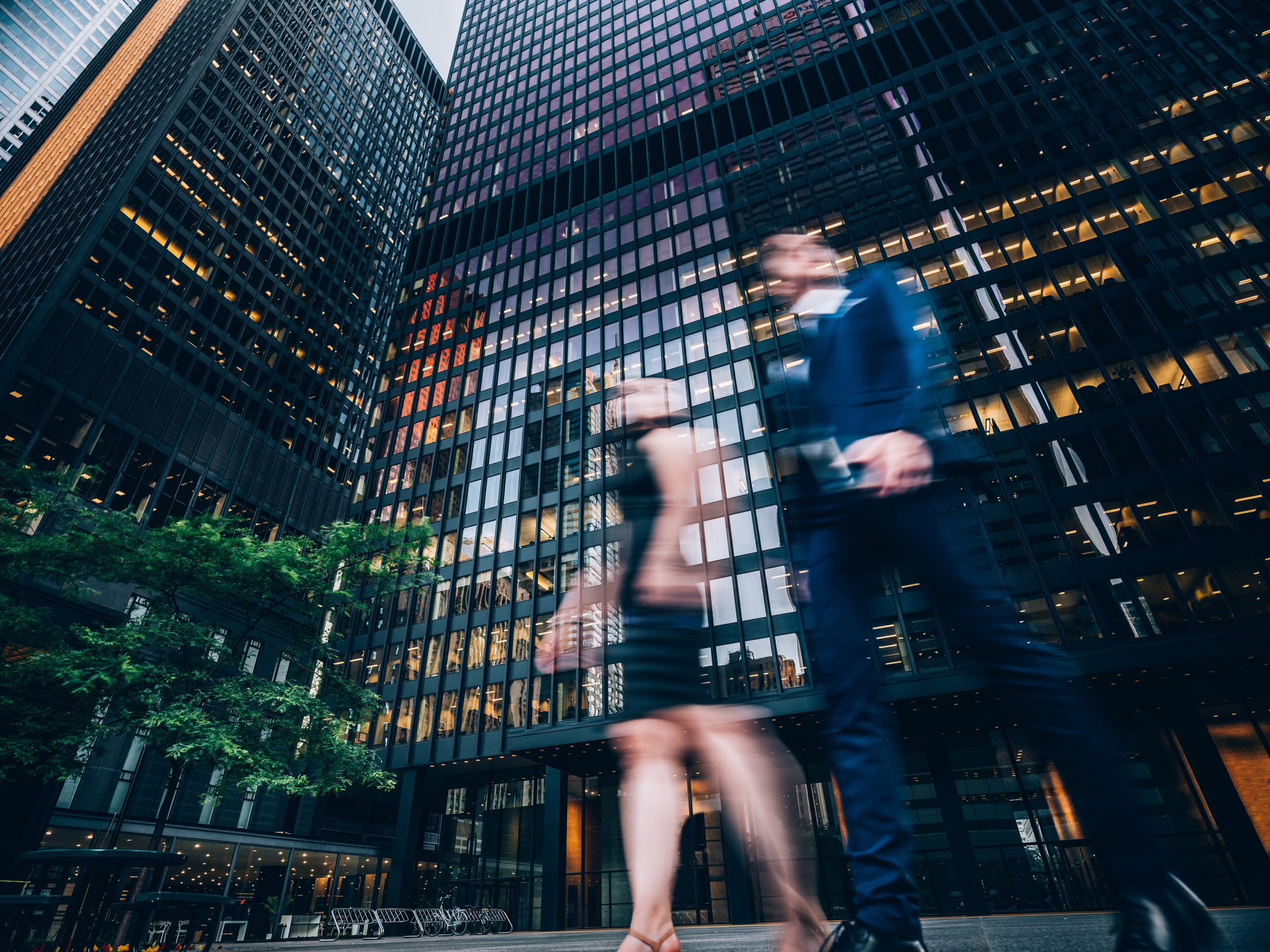 Two business people walking on downtown street. Blurred motion effect.