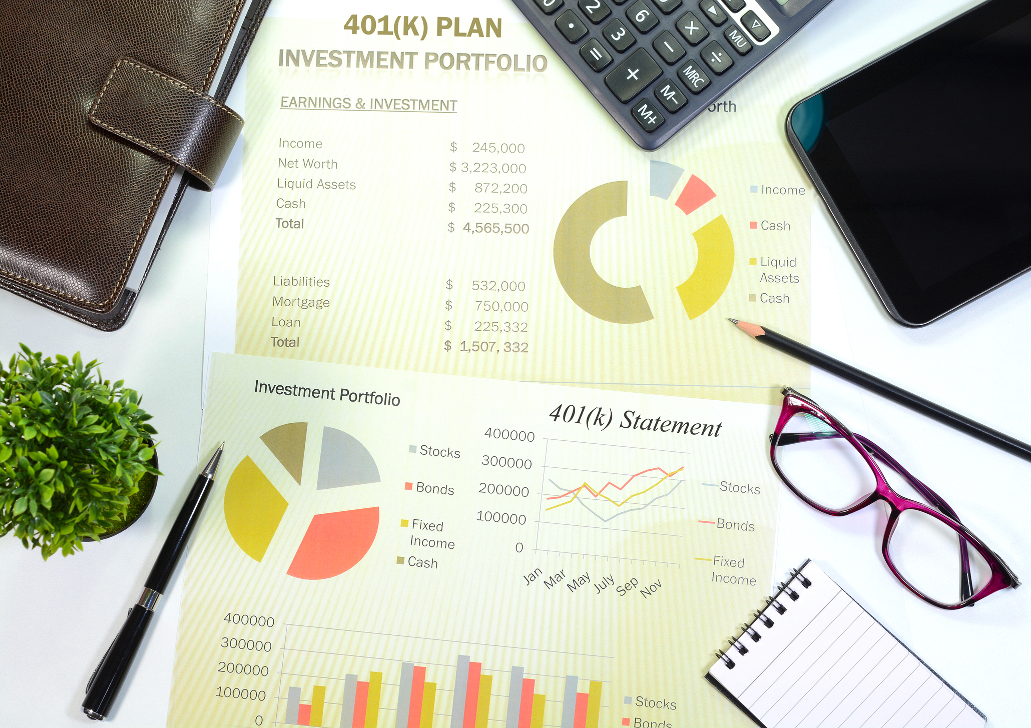 401k retirement portfolio reports, eye glasses, pen, calculator and personal organizer on a desk.