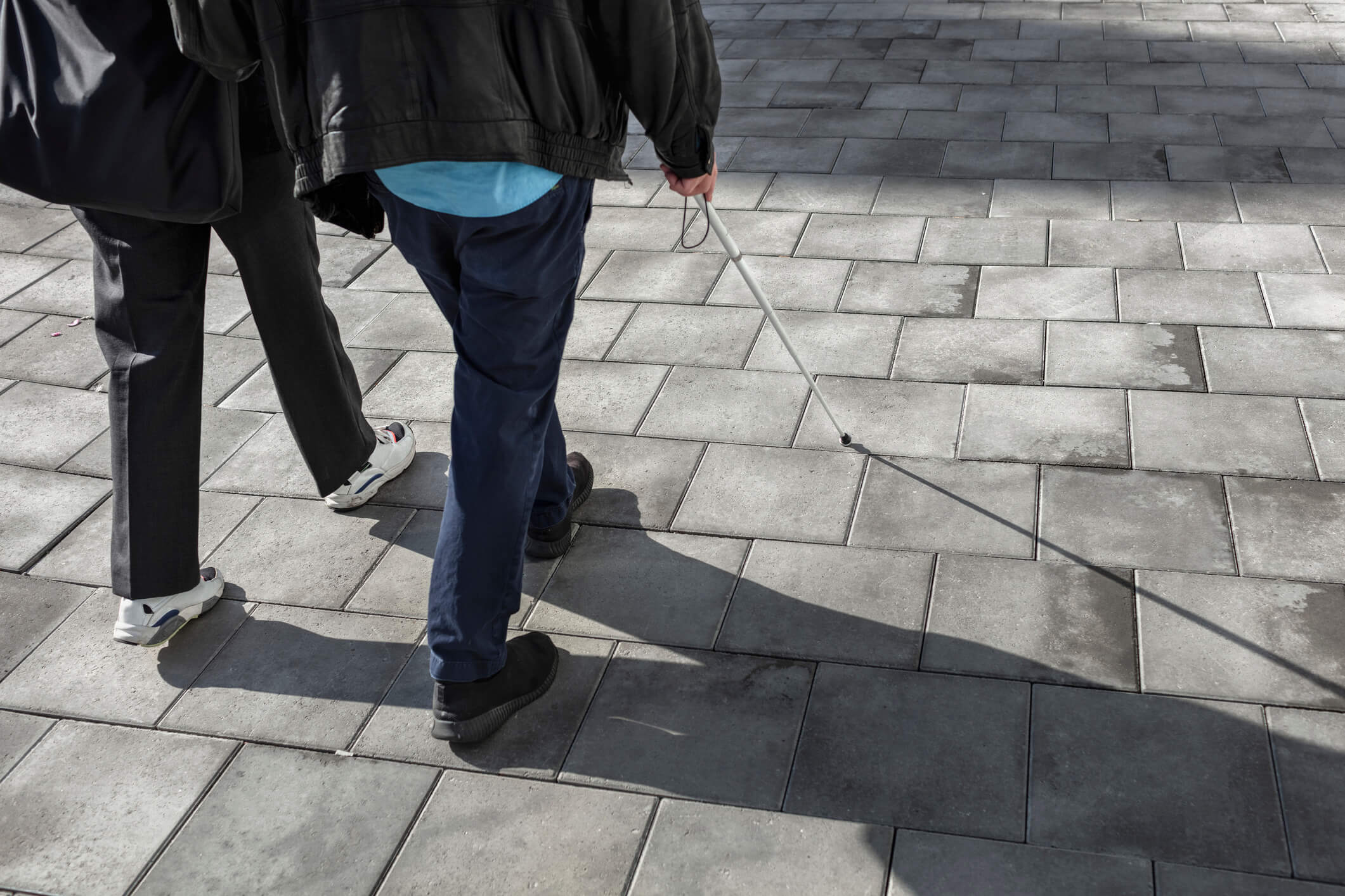 Couple with white cane walking in street