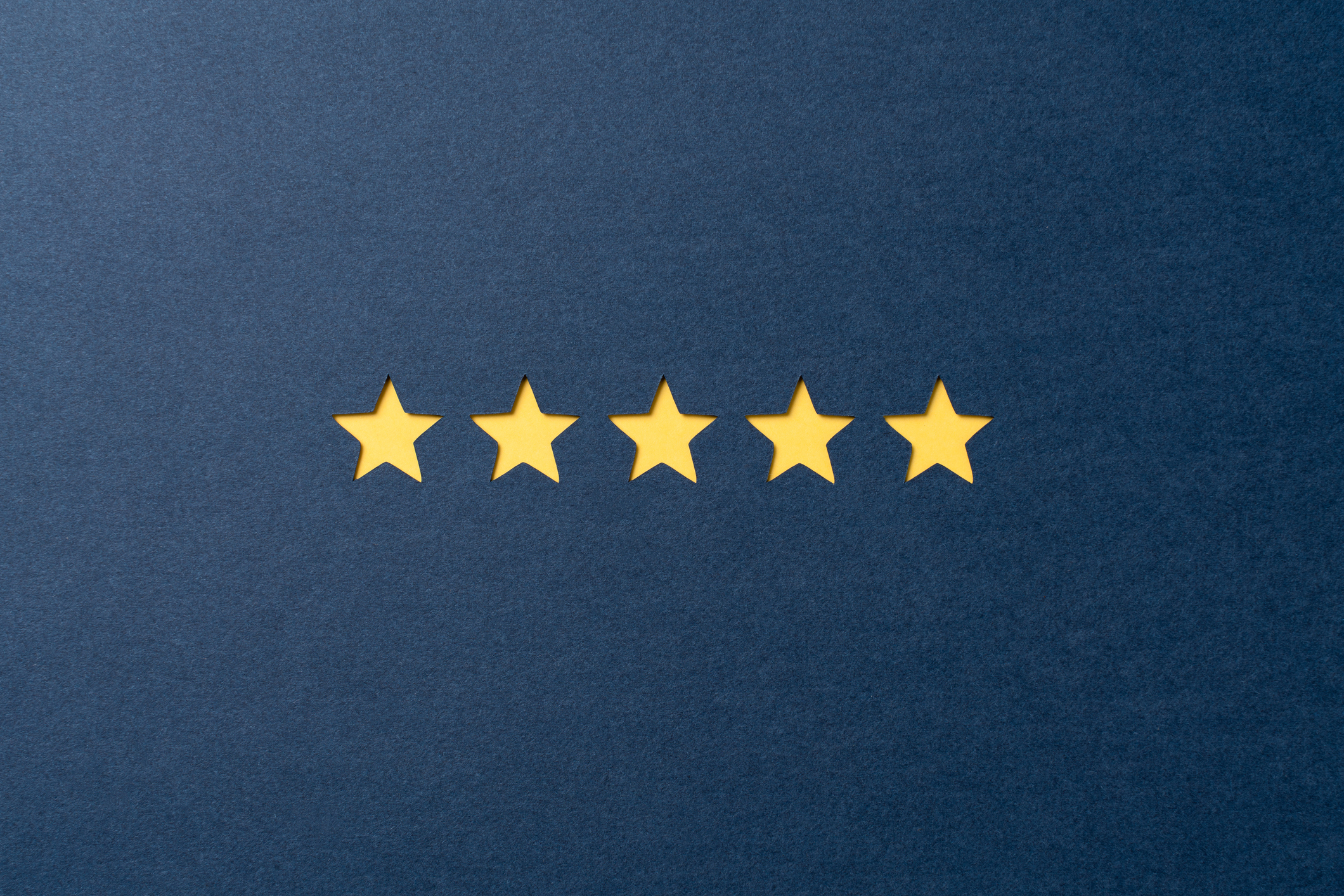 Paper Craft of Five Star Rating for Satisfaction Review Concept, Perfection Concept. Yellow Colored Star Shape Review on Blue Background Directly Above View.