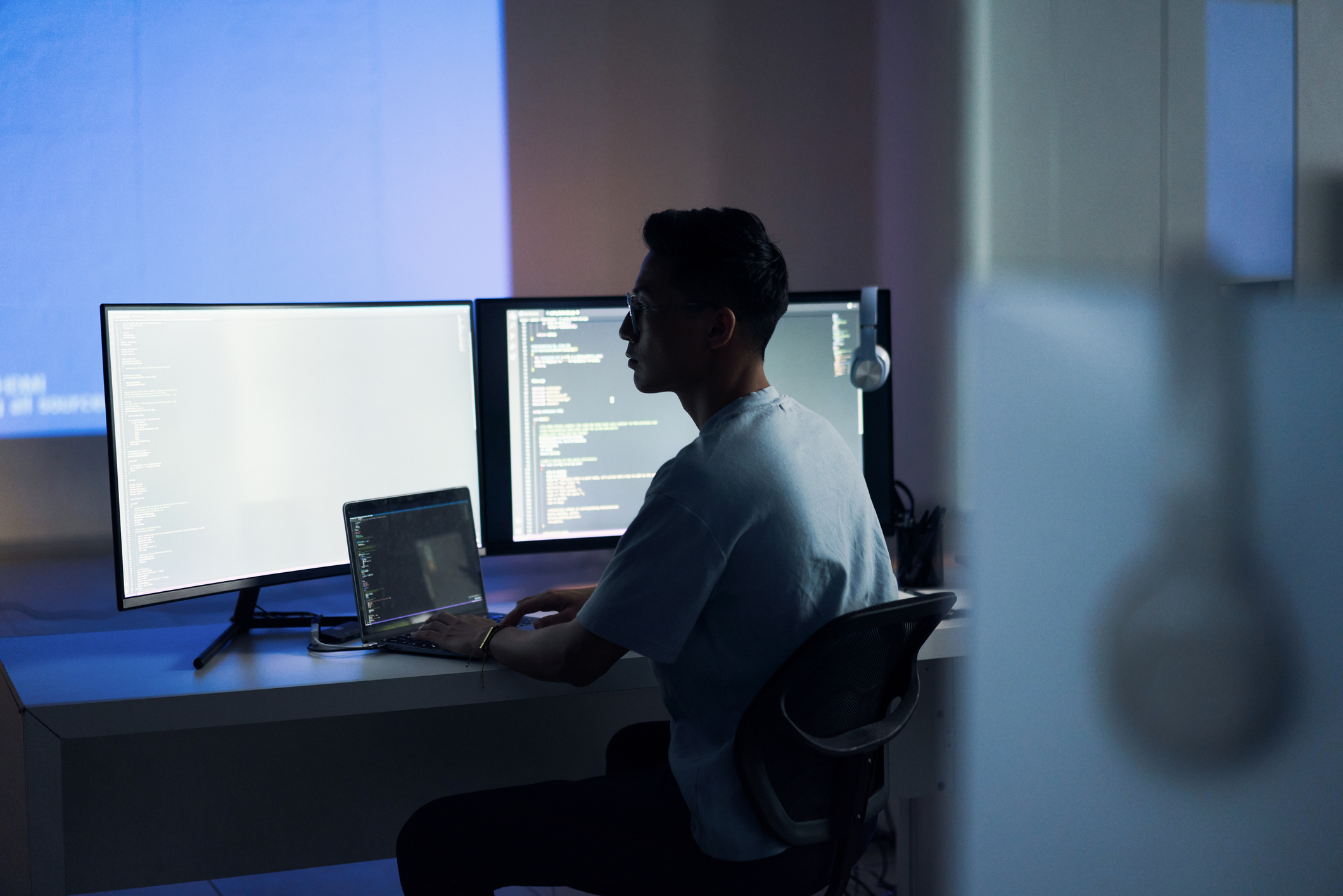 Web design, coding and Asian man with a computer for programming a website at night. Cyber security, developer and programmer reading information for a software database on a pc in a dark office