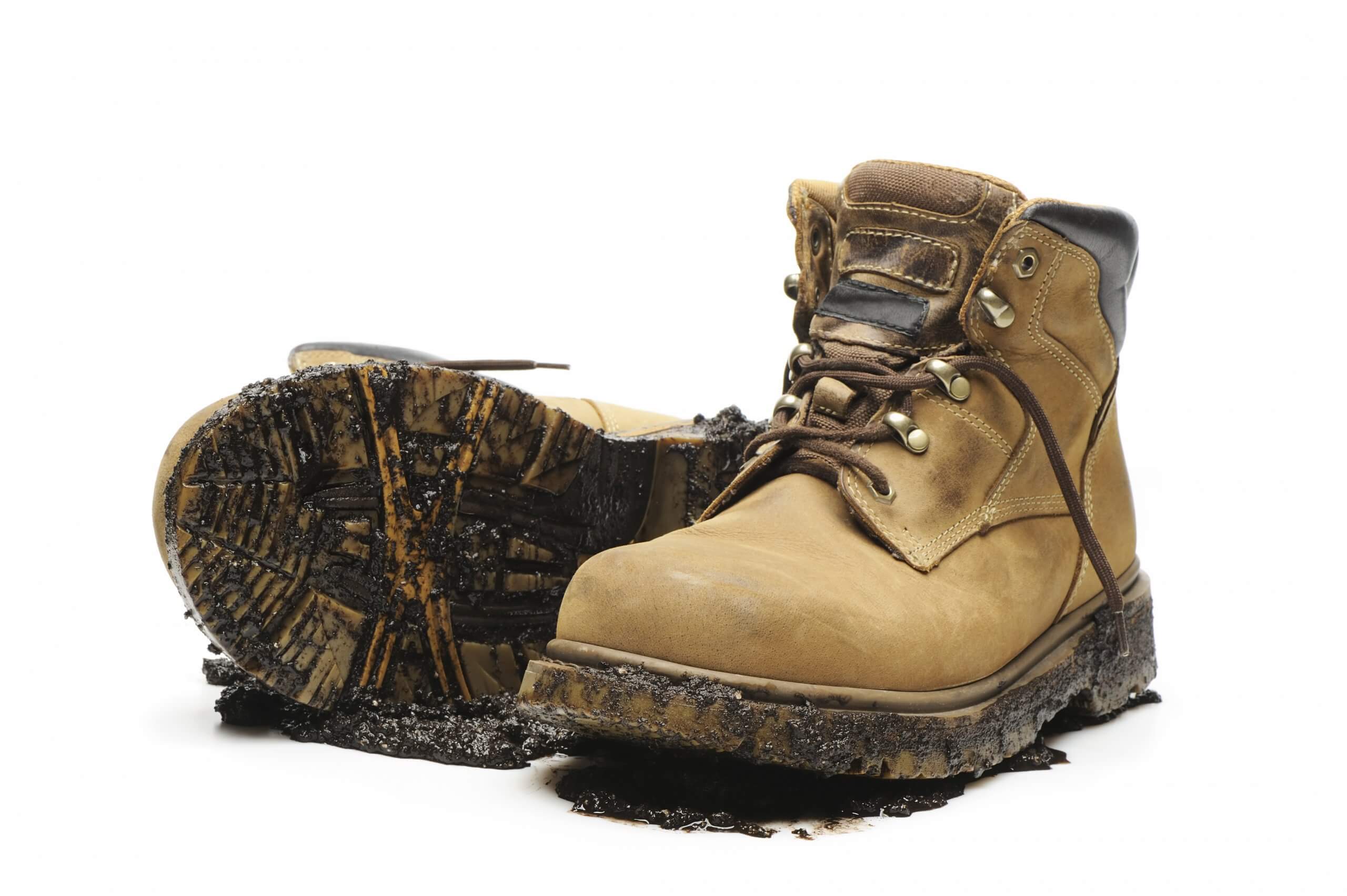 pair of work boots with mud on the soles